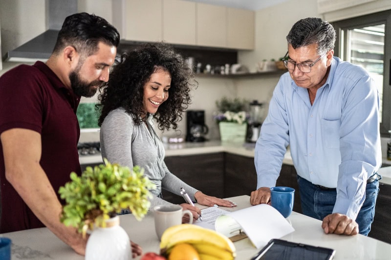 A Guide to Indoor Humidity Control. Mid adult couple filling document in the kitchen at home.